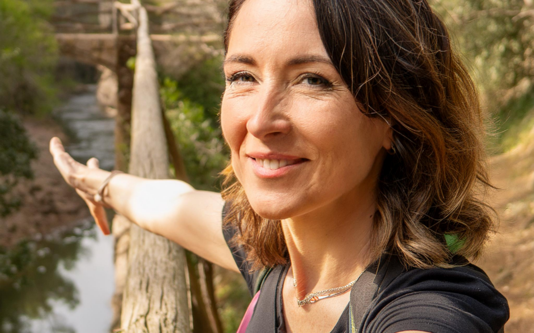 Mut zum Weitergehen Eine Frau steht auf einer Holzbrücke in der Natur und beugt sich an das Holzgeländer